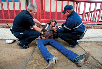 Gallup Firefighters Lt. Michael Hoffman and Craig Carver assist a drunken man in downtown Gallup in this Jan. 22, 2009, file photo. The man was found passed out along Second Street with a Listerine bottle at his side. Copyright &copy; 2010 Gallup Independent